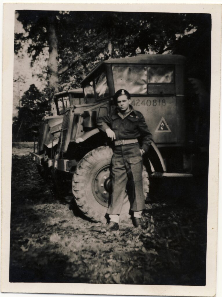 Trooper Frank Edwards (Sherbrooke Fusilliers) leans against truck. 1943.